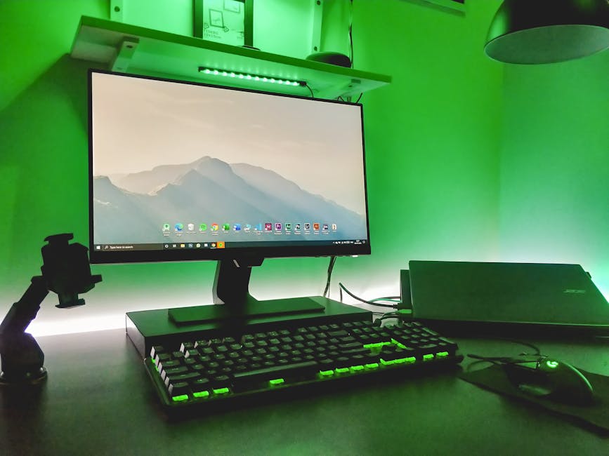 Stylish workspace featuring a desktop, keyboard, and ambient green LED lighting.