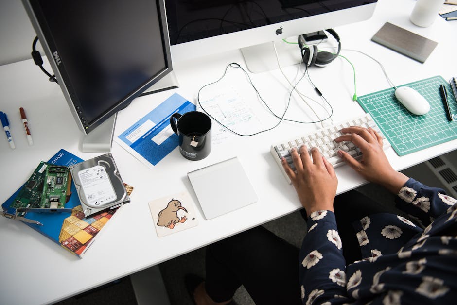 Overhead view of a person typing at a desk in a modern office environment